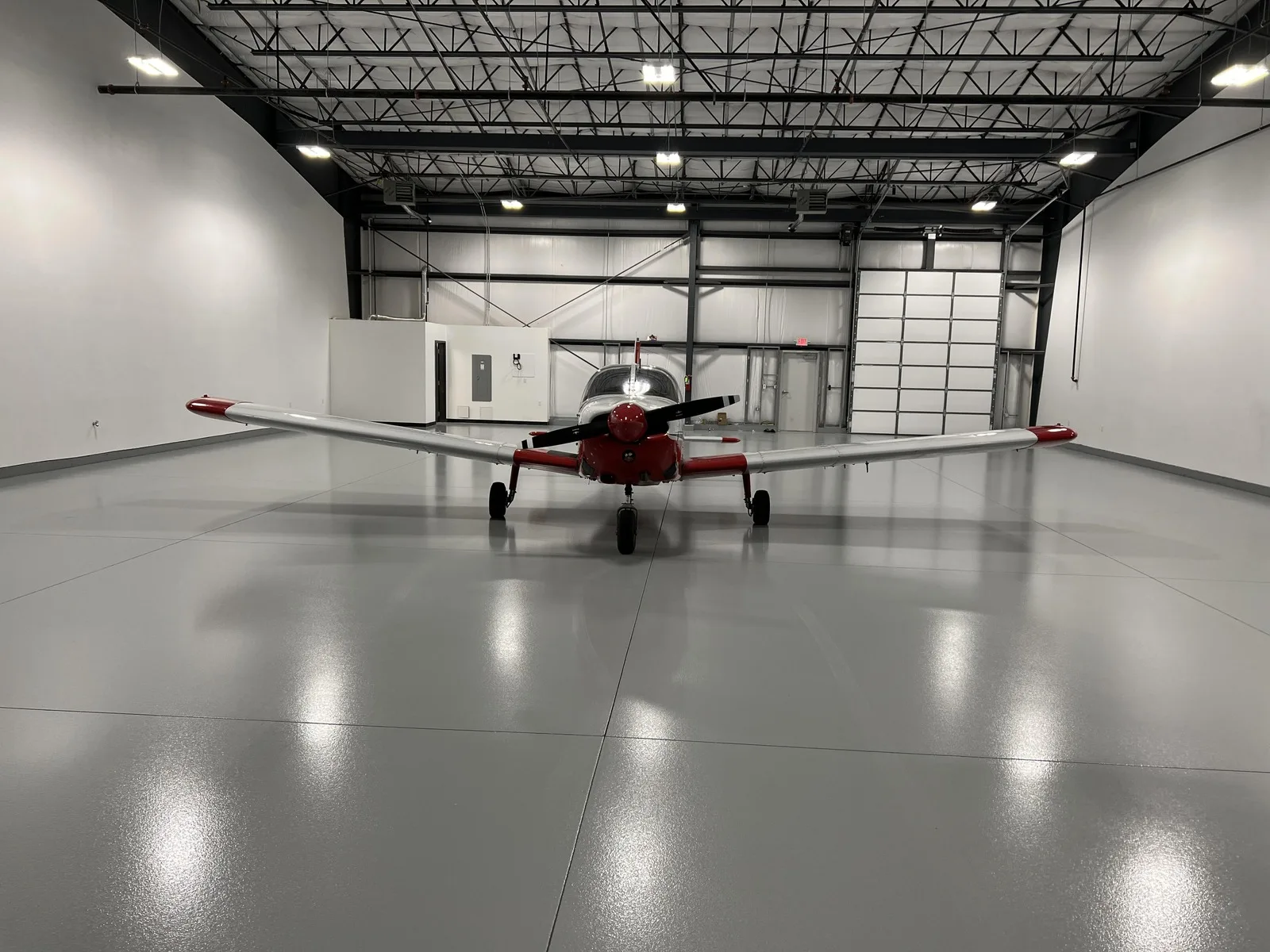Epoxy floor in an airplane hangar with a plane parked on it