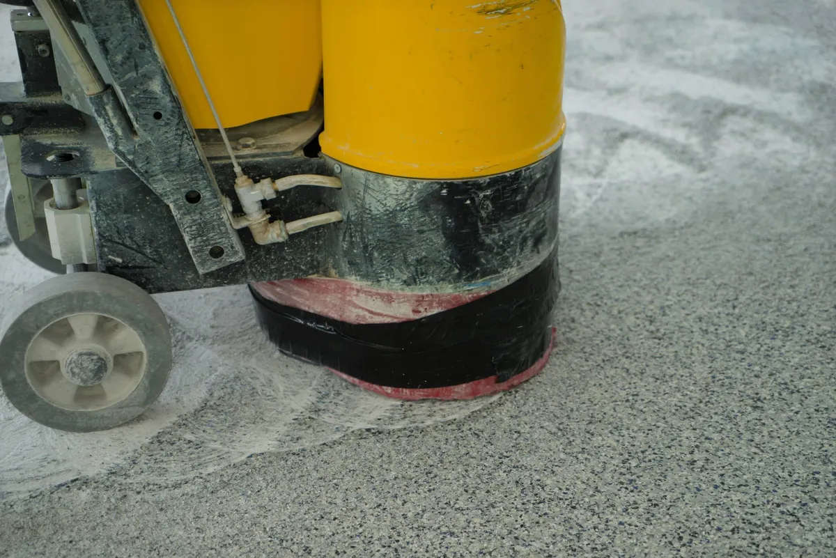 Diamond grinder opening a bare concrete floor before a coating