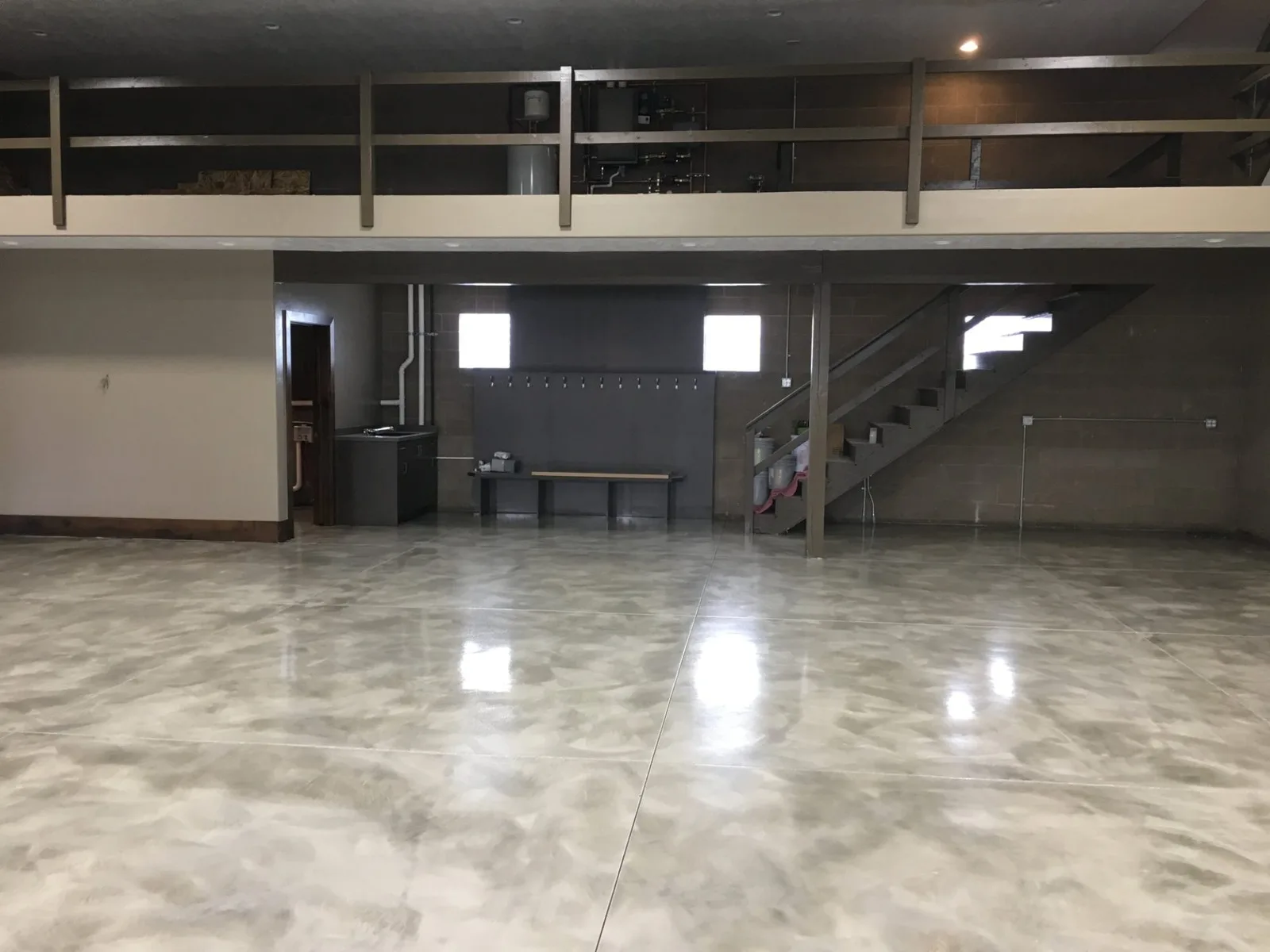 Open basement floor finished in gray metallic epoxy