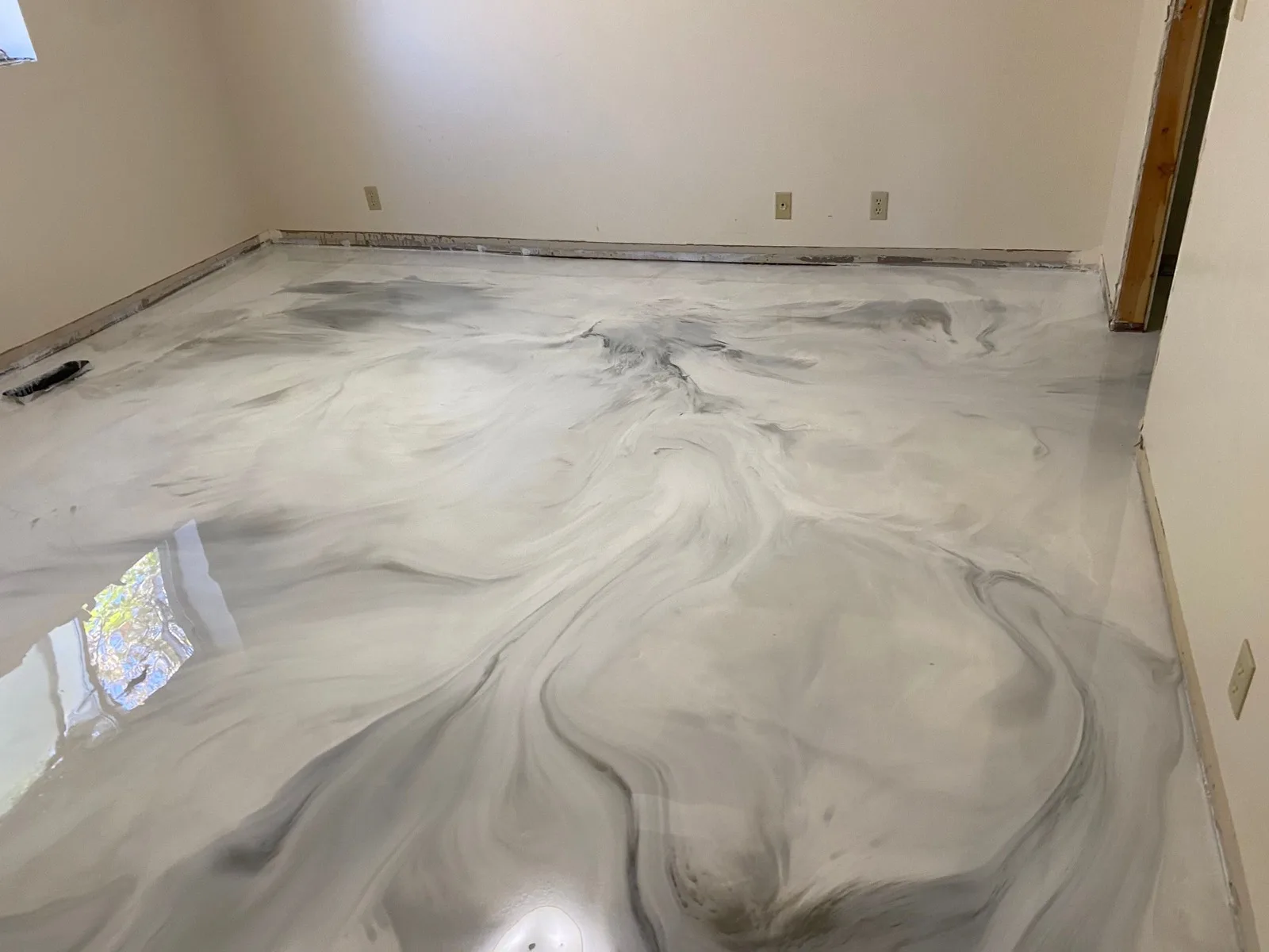 Marble look metallic epoxy floor in a finished lower level