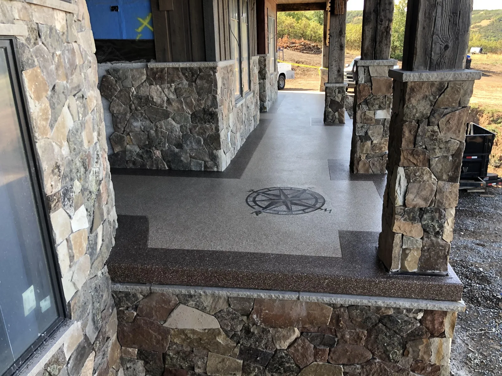 Compass stencil patio coating between stone columns