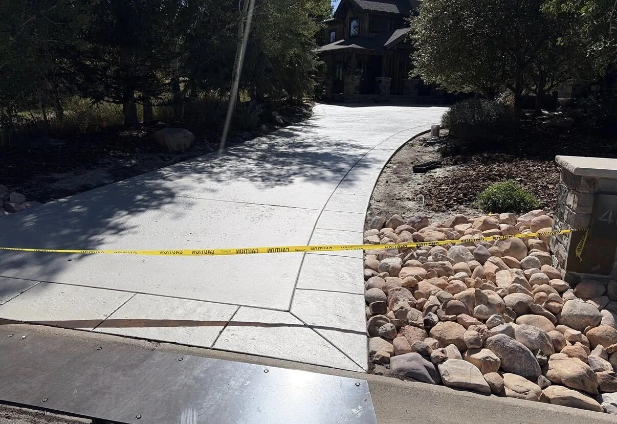 Freshly resurfaced concrete driveway curing behind caution tape