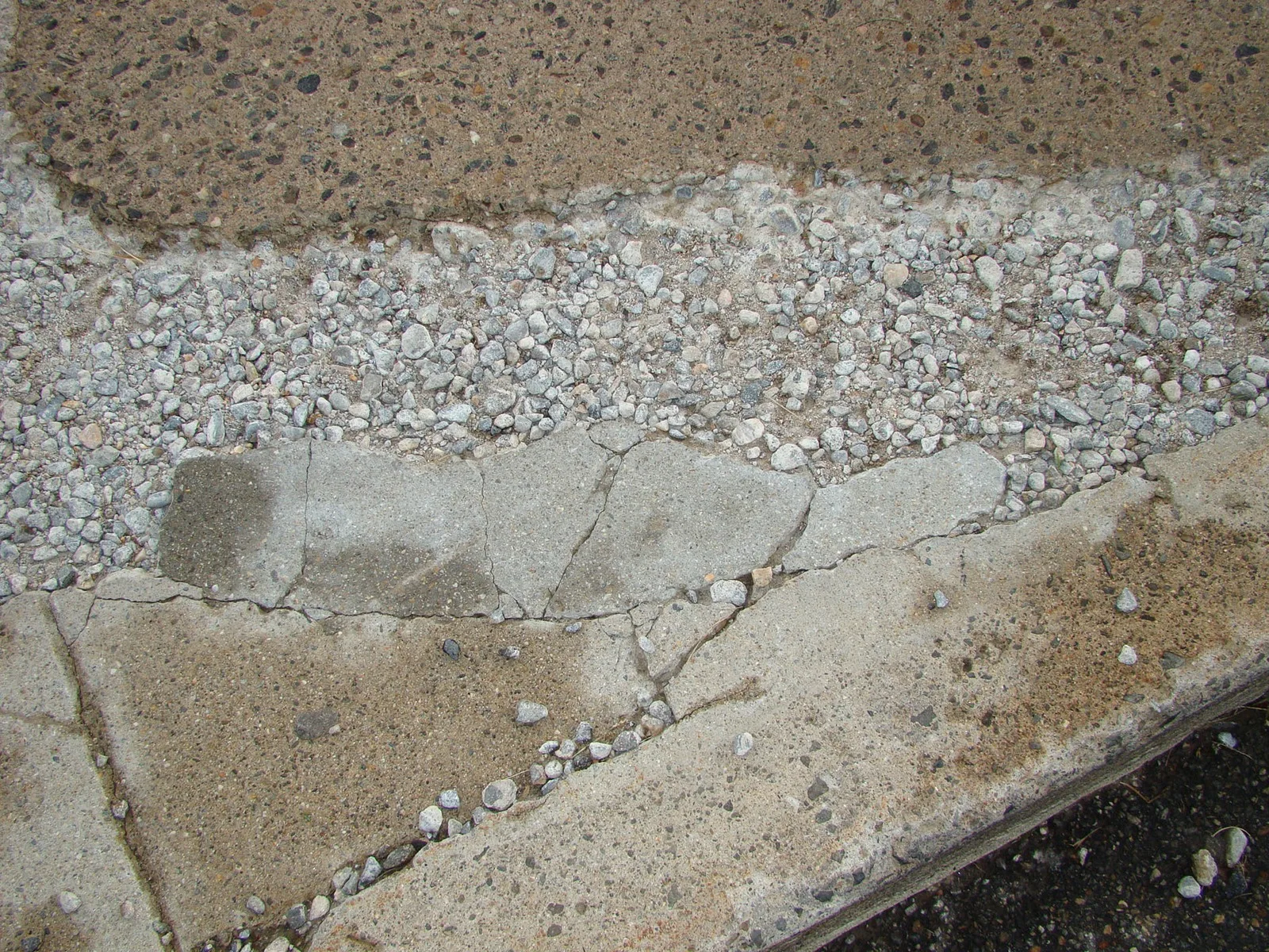Spalled concrete edge with exposed aggregate before repair
