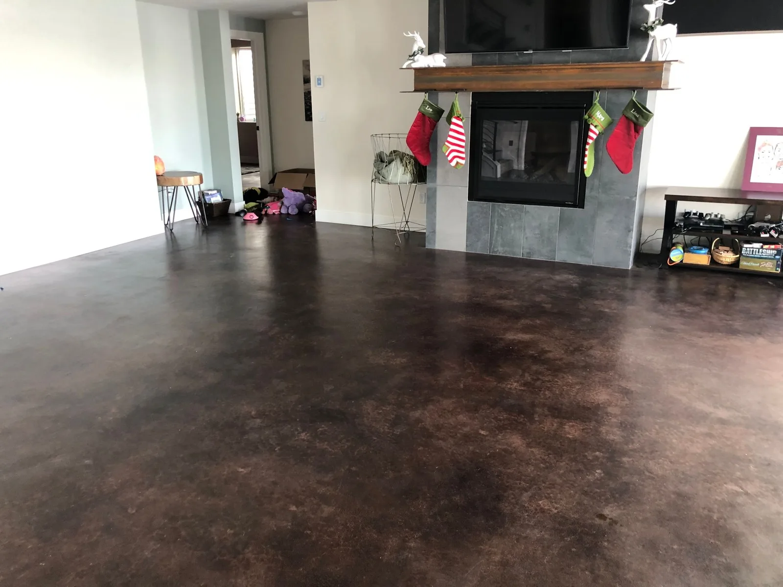 Stained concrete floor in a living room beside a fireplace