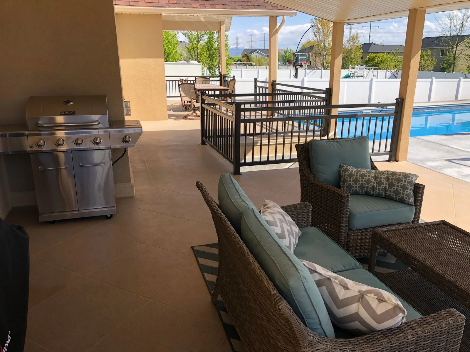 Waterproof deck coating on a covered Utah deck with a grill and pool view